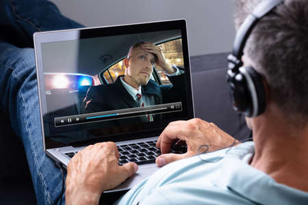 Relaxed Man Wearing Headphone Watching Video On Laptop