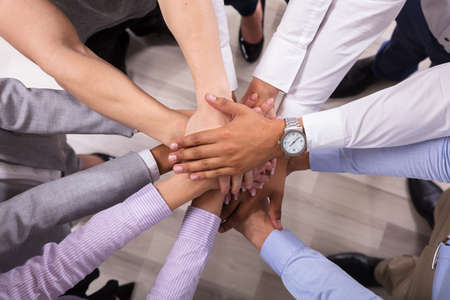 Elevated View Of Businesspeople Stacking Hands Over Each Otherの写真素材