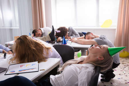 Group Of Businesspeople Sleeping In Office After New Year Partyの写真素材