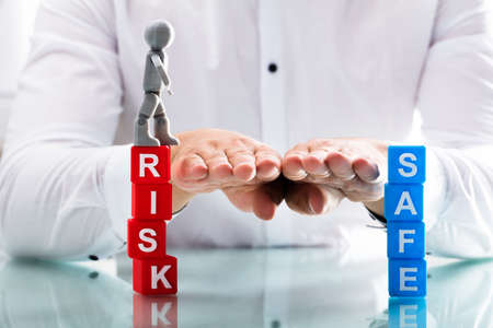 Close-up of a person's hand assisting human figure while moving from risk to safe blocks