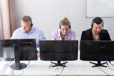 Young Customer Service Executives Using Earphones Working In Call Centerの写真素材