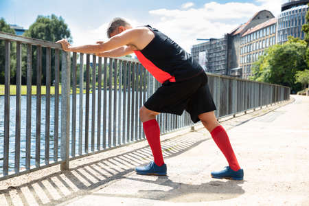 Side View Of A Man Doing Push-Ups On Railing At Outdoors