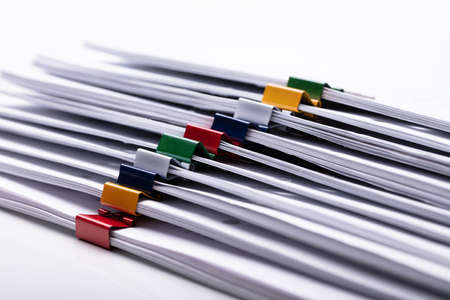 Close-up Of Stacked Documents With Colorful Paperclipsの写真素材
