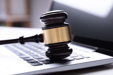 Close-up Of Wooden Gavel On Laptop Keypadの写真素材