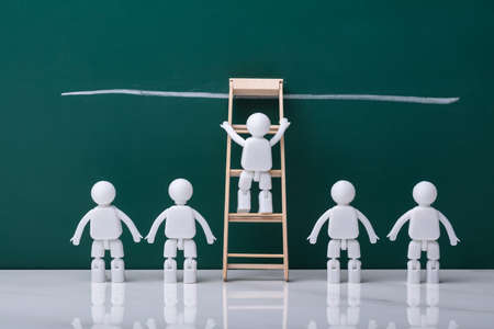 Human Figure Climbing Ladder To Reach Finish Line On Chalkboardの写真素材