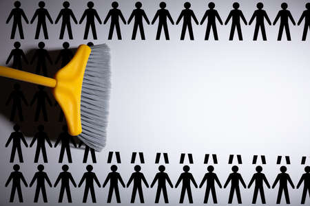 Broom Sweeping Human Figures Over Grey Backgroundの写真素材