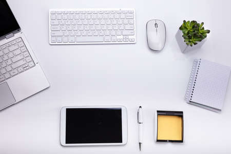 Elevated View Of Various Electronic Devices And Stationeries On White Background