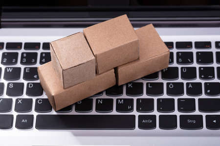Close-up Of Small Cardboard Boxes On Laptop Keypadの写真素材