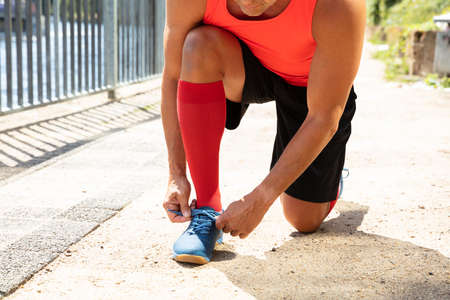 Male Athlete Tying Shoelace Getting Ready For Jogging