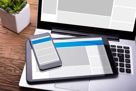 Electronic Devices With Screen On Wooden Desk Near Diary And Penの写真素材