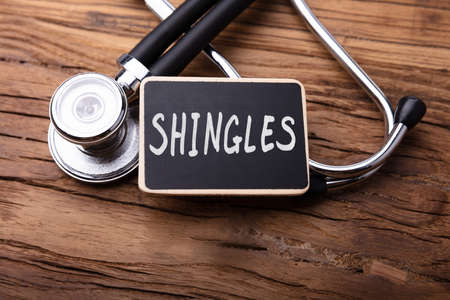Close-up Of Shingles Word With Stethoscope On Wooden Table