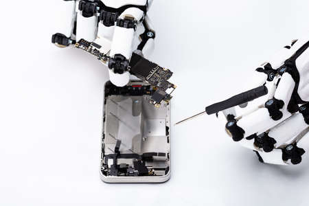 Robotic Hand Repairing Mobile Phone On White Backgroundの写真素材