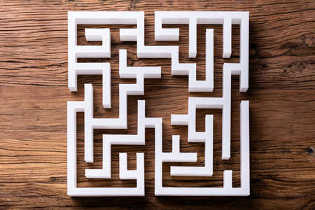 Overhead View Of Abstract White Maze On Wooden Background