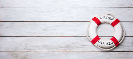 Elevated View Of Lifebuoy With Welcome Aboard Text On Wooden Plank