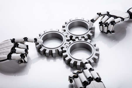 Robotic Hands Connecting Gears On White Background
