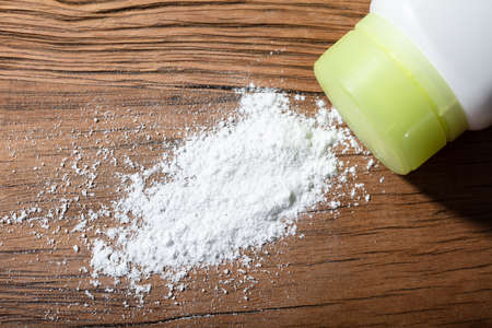 Close-up Of Spilled Talcum Powder On Wooden Desk