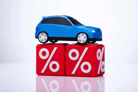 Blue Car Over Cubic Blocks With Red Percentage Sign On White Backgroundの写真素材