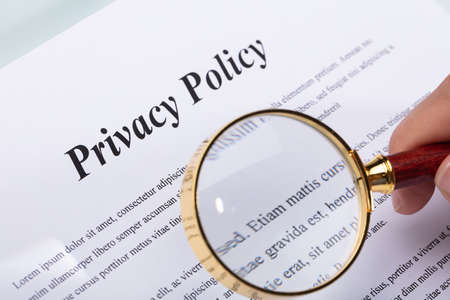 Close-up Of A Woman's Hand Holding Pen Over Privacy Policy Formの写真素材