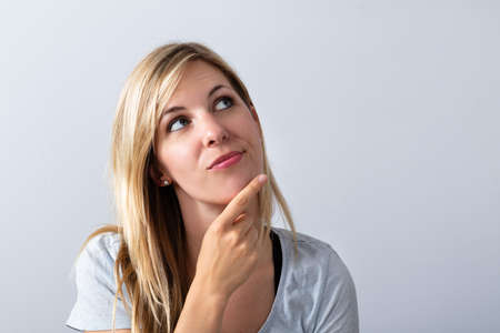 Portrait Of A Young Thoughtful Woman On Grey Background