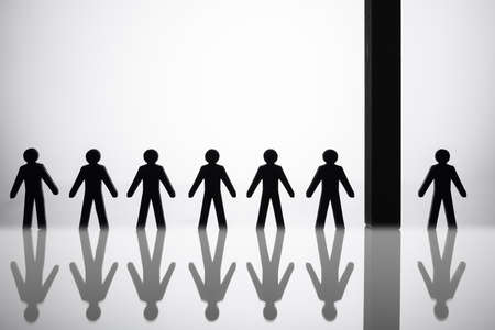 Human Figure Separated By Block From Others Standing In A Rowの写真素材