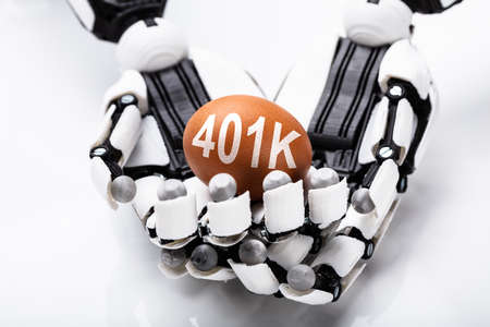 Close-up Of Robot Holding 401k Brown Egg On White Backgroundの写真素材