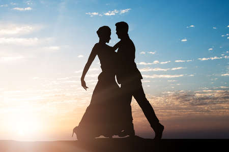 Silhouette Of A Dancing Couple Against Sky At Dusk