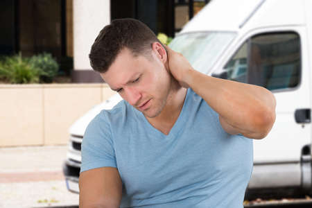 Close-up Of A Young Man Suffering From Neck Painの写真素材