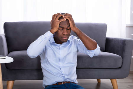 Portrait Of A Displeased African Man Touching His Headの写真素材