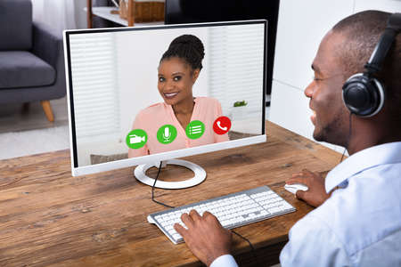 Man Video Conferencing With Young Woman On Computerの写真素材