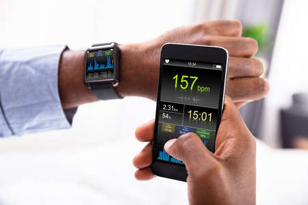 Close-up Of A Man's Hand With Smartwatch And Cellphone Showing Heartbeat Rate