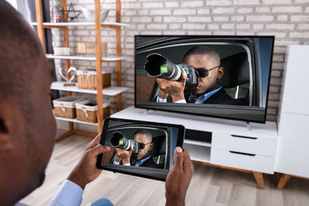 Man Connecting Television Channel Through Wireless On Digital Tablet At Home