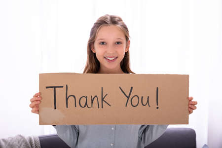 Portrait Of A Happy Girl Holding Thank You Placardの写真素材