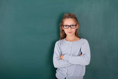 Portrait Of A Female Student In Front Of Green Chalkboardの写真素材