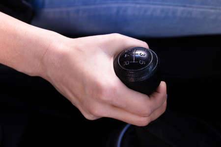 Close-up Of A Woman's Hand Changing Gear While Driving Car