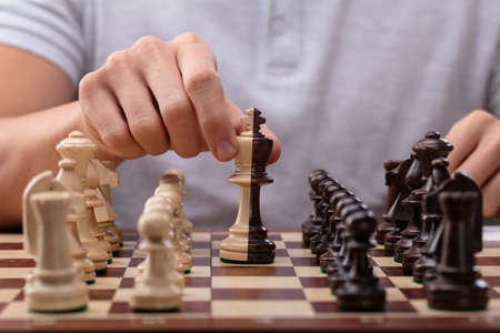 Man's Hand Moving A King Chess Piece