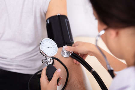 Close-up Of Doctor Measuring Blood Pressure Of Male Patient