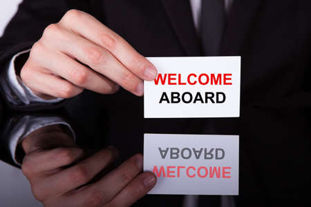 A Person's Hand Holding Welcome Aboard Card