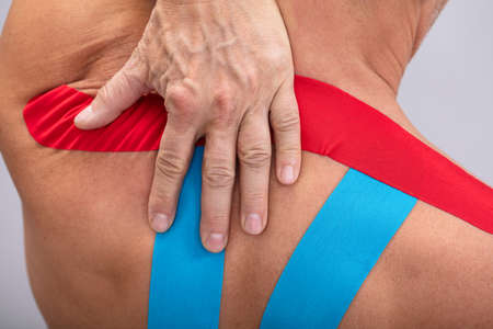 Shirtless Man With Physio Tape Applied On His Body. Body shape was altered during retouching