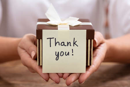 Close-up Of Thank You Adhesive Note On Gift Box Over The Deskの写真素材