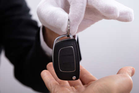 Close-up Of Valet's Hand Giving Car Key To Manの写真素材