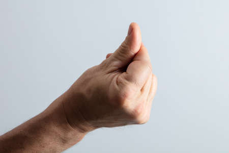 Close-up Of Man's Hand Snapping His Finger Against Gray Background