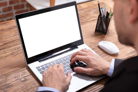 Close-up Of A Young Man Using Laptop With Blank White Screen