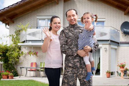 Close-up Of A Happy Soldier Reunited With Family Outside Their Homeの写真素材