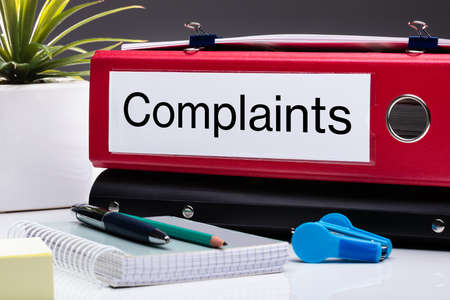 Close Up Of Compliance Folder And Office Supplies On Office Deskの写真素材