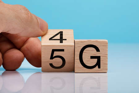 Man's Hand Changing Wooden Block From 4g To 5g On White Surfaceの写真素材
