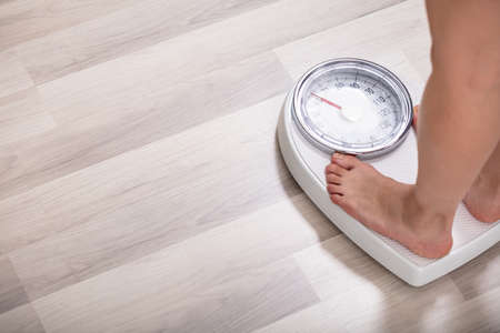 Low Section Of Woman Foot On Weighting Scale At Homeの写真素材