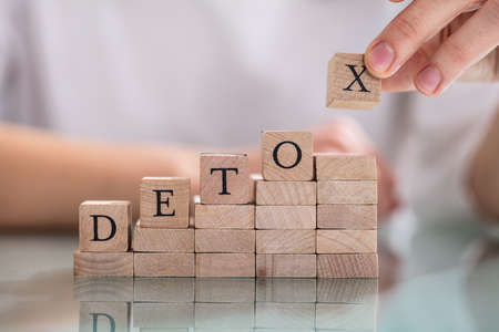 Businesswoman's Hand Putting The Letter Of Word Detox On Stack Of Blockの写真素材