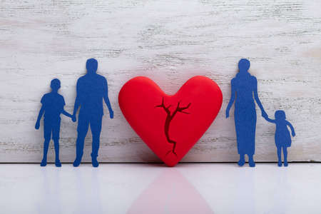 Broken Heart Between Cutout Blue Family Against White Textured Backgroundの写真素材