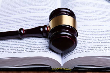 Close-up Of Wooden Gavel And Open Law Book