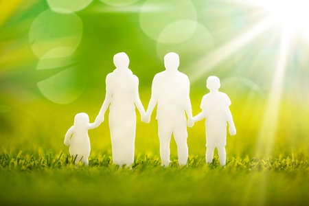Close-up Of Paper Family Cut Out On Green Grassの写真素材